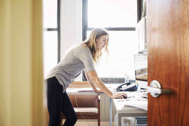Woman standing over desk — Stock Photo