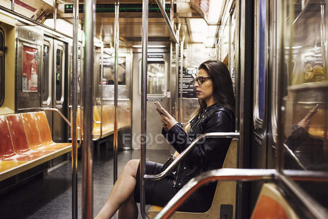 Женщина сидит в вагоне метро — стоковое фото
