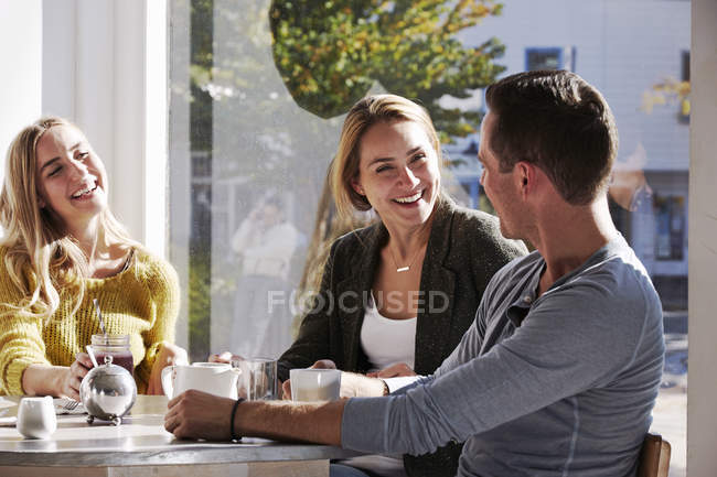 Gente sentada en la cafetería - foto de stock
