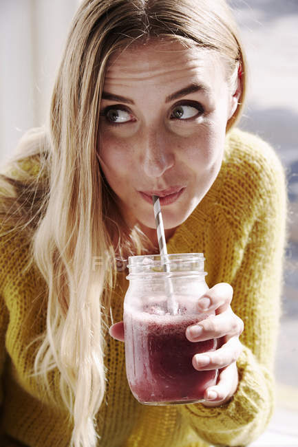 Woman sipping smoothie — Stock Photo