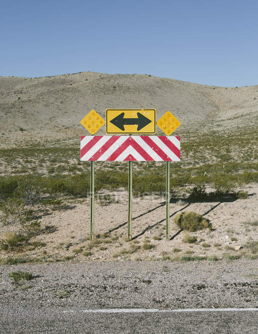 Directional arrow and caution sign — Stock Photo