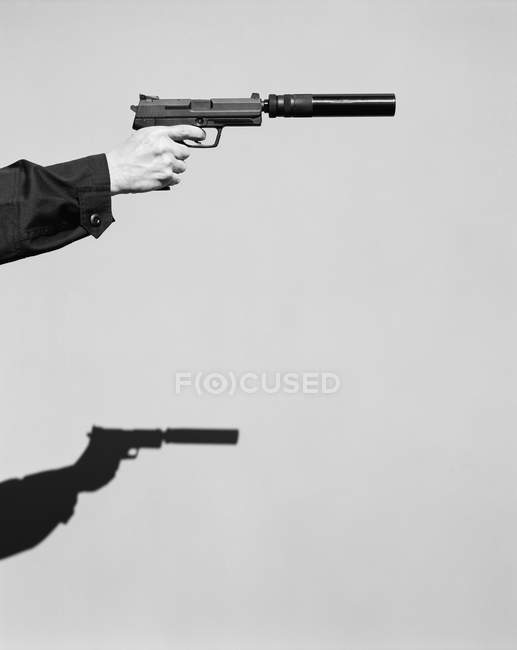 Main masculine visant avec arme de poing — Photo de stock