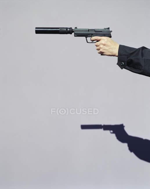 Main masculine visant avec arme de poing — Photo de stock