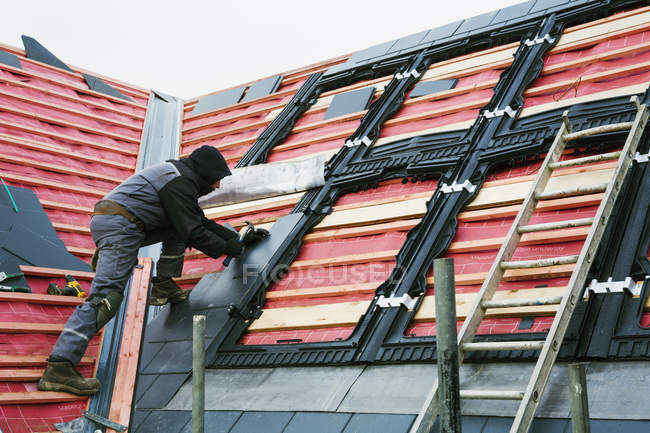 Roofer replacing the tiles — Stock Photo