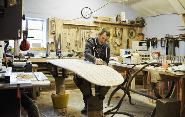 Man in surfboard workshop — Stock Photo