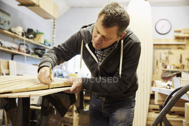Mann arbeitet in Holzwerkstatt. — Stockfoto