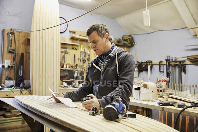 Man in surfboard workshop — Stock Photo