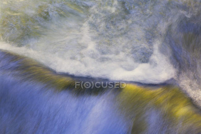 Вода, текущая над валуном — стоковое фото