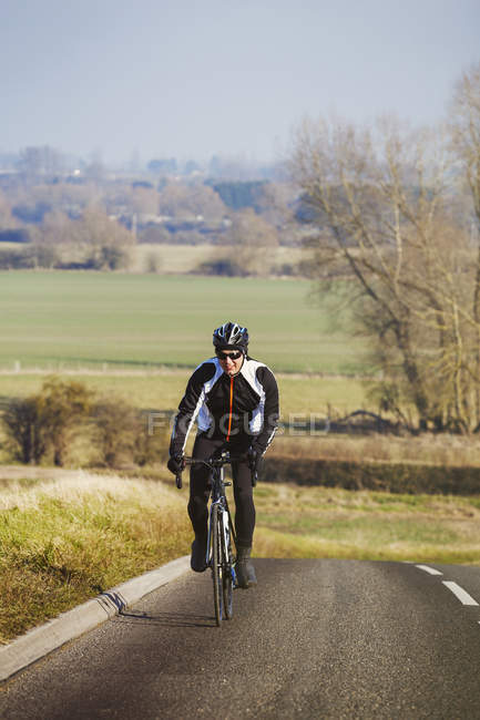 Man pedalling out of saddle on road bike — Stock Photo