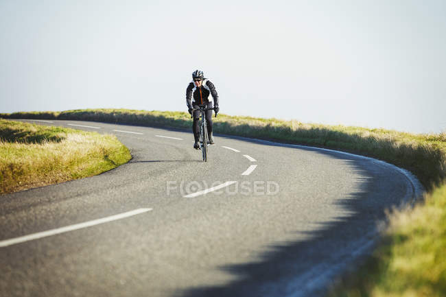 Radfahrer fährt auf Landstraße — Stockfoto