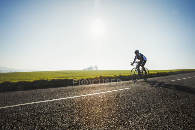 Radfahrer fährt auf Landstraße — Stockfoto