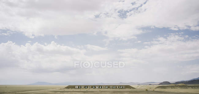Números en la pared en el paisaje del desierto - foto de stock