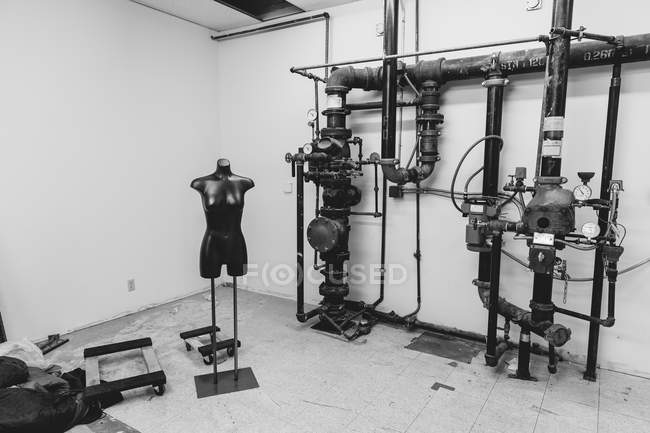 Mannequin placed next to industrial pipework — Stock Photo