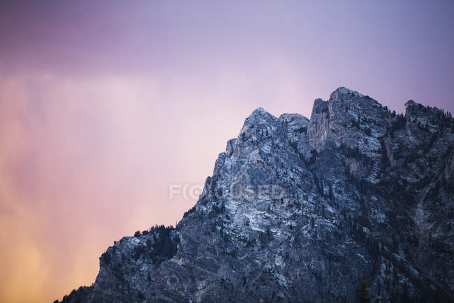 Rocky mountain against colourful sky — Stock Photo