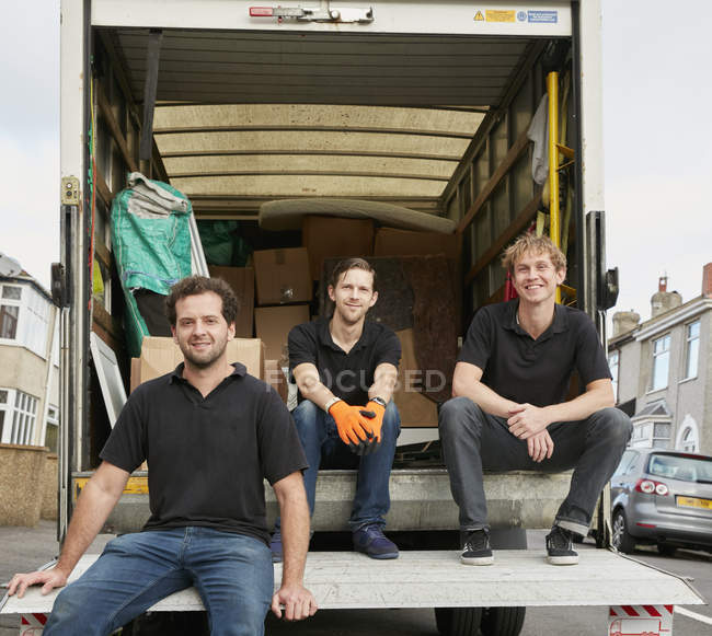 Три чоловіки в чорних сорочках сидять — стокове фото