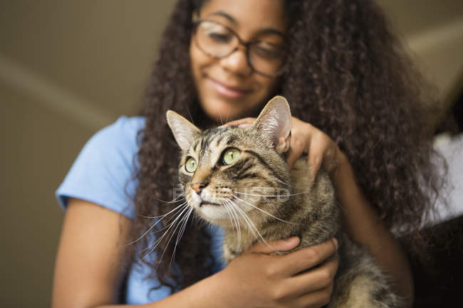 Chica con gato de mascota en regazo - foto de stock