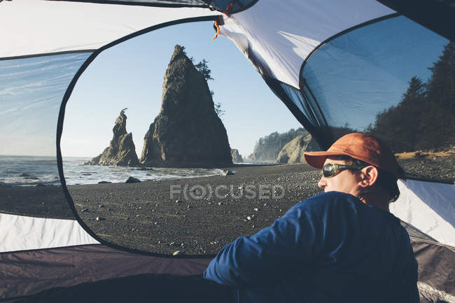 Man sitting in camping tent — Stock Photo