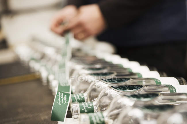 Uomo etichettatura bottiglie di vetro — Foto stock
