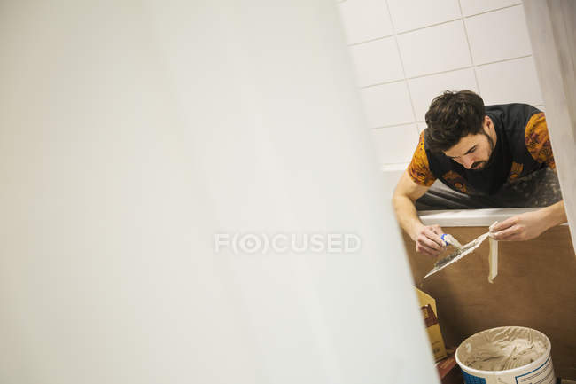 Constructeur, carreleur travaillant dans une salle de bain — Photo de stock