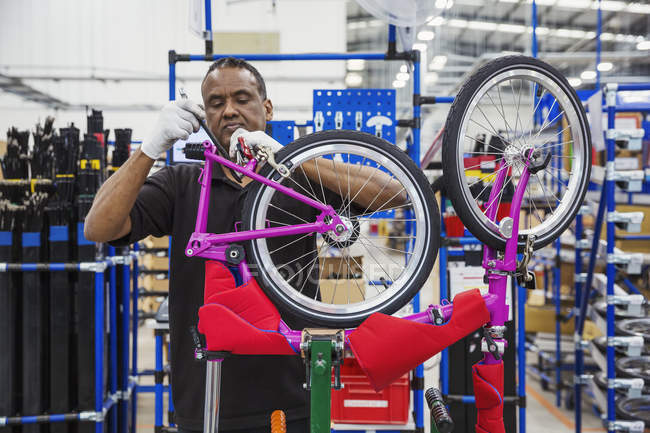 Worker assembling bicycle — Stock Photo