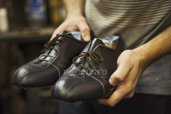 Man holding pair of shoes — Stock Photo