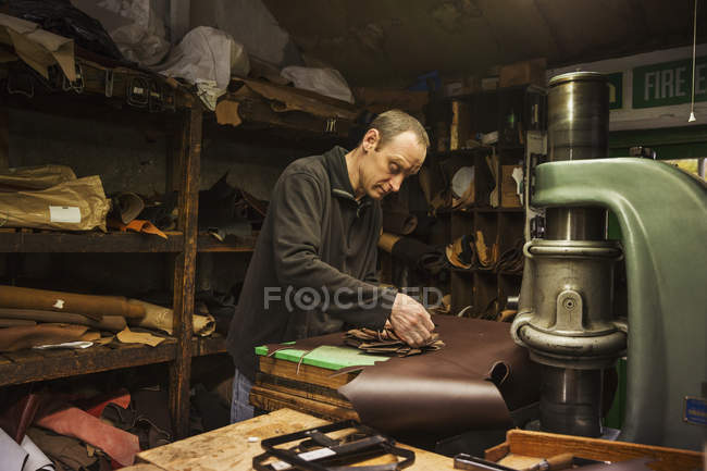 Hombre parado en el taller de un zapatero - foto de stock
