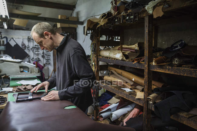 Mann steht in Schuhmacherwerkstatt — Stockfoto