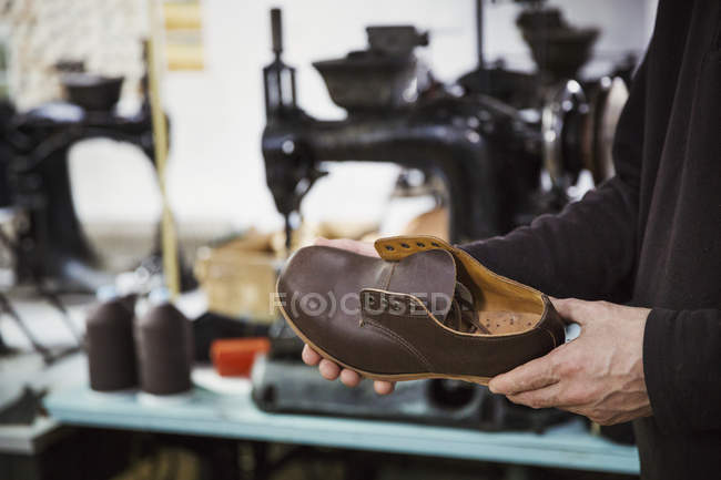 Mann steht in Schuhmacherwerkstatt — Stockfoto