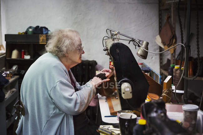Mujer mayor sentada, trabajando - foto de stock