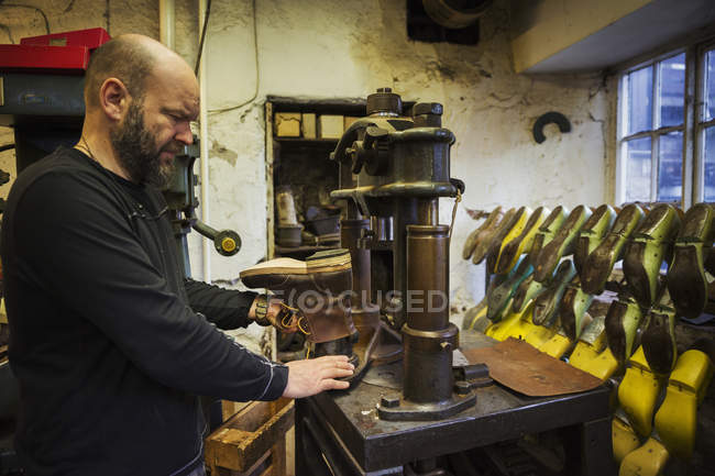 Homme debout dans un atelier de cordonnier — Photo de stock