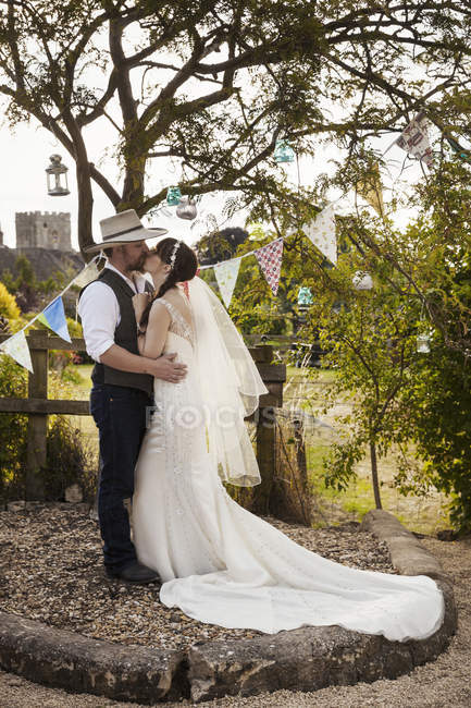 Jeunes mariés debout à l'extérieur — Photo de stock