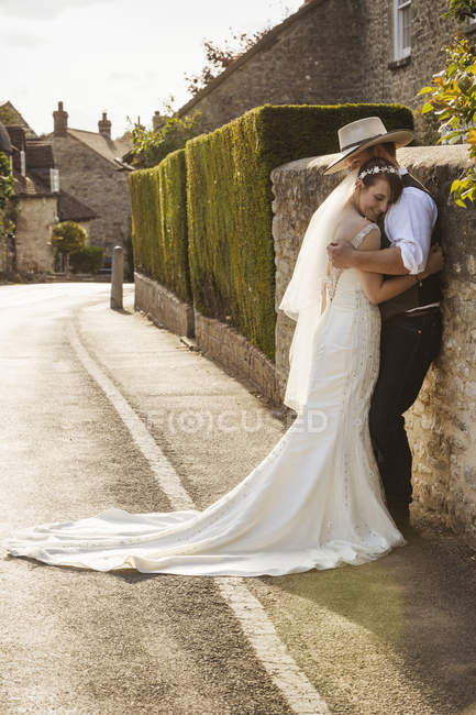 Jeunes mariés debout à l'extérieur — Photo de stock