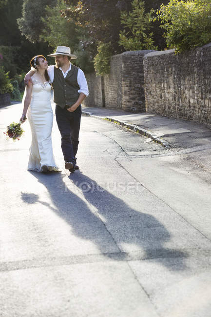 Novia y novio caminando por la calle
. - foto de stock