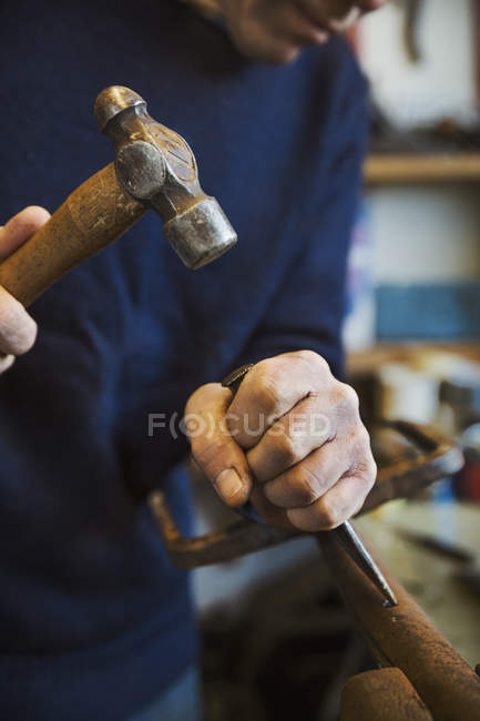 Homem segurando martelo e chise de madeira — Fotografia de Stock