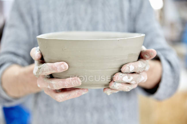 Человек держит глиняный горшок — стоковое фото