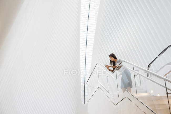 Donna sulle scale appoggiata alla ringhiera — Foto stock