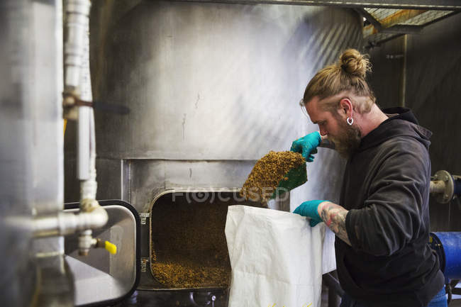 Uomo raschiando spalatura grano esaurito — Foto stock