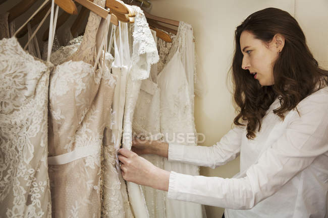 Mulher escolher vestidos de noiva — Fotografia de Stock