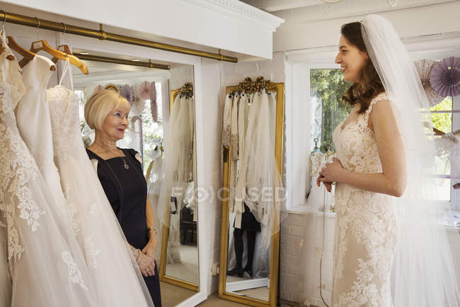 Frau probiert Hochzeitskleider an — Stockfoto