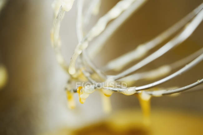 Batter dripping off metal whisk. — Stock Photo