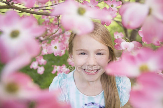 Jeune fille regardant à travers la fleur — Photo de stock