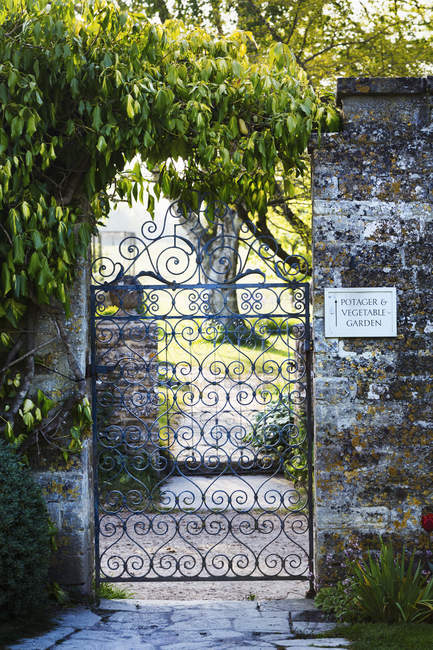 Cancello in ferro battuto in un giardino . — Foto stock
