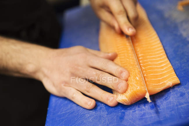 Cutting a fillet of salmon — Stock Photo
