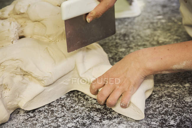 Person portioning bread — Stock Photo