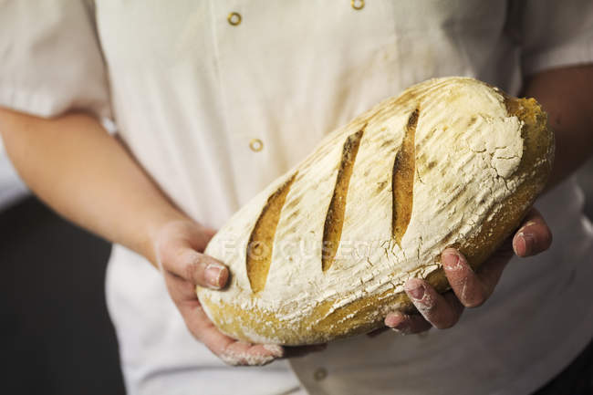 Person holding laof of bread. — Stock Photo