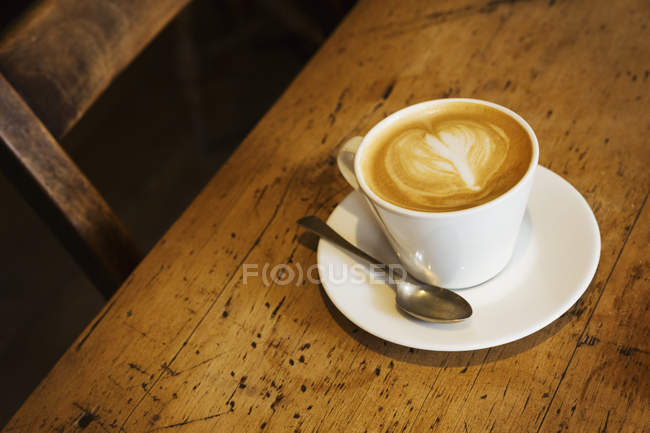 Xícara de cappuccino na mesa de madeira rústica — Fotografia de Stock