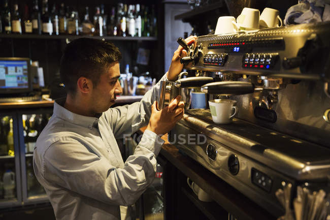 Uomo in piedi su una macchina da caffè espresso — Foto stock