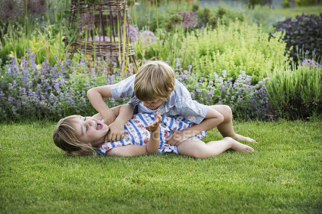 Улыбающиеся мальчик и девочка в саду — стоковое фото