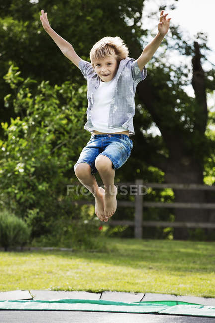 Garçon sautant sur trampoline — Photo de stock