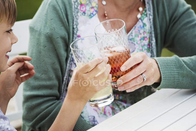 Woman and boy clinking glasses — Stock Photo